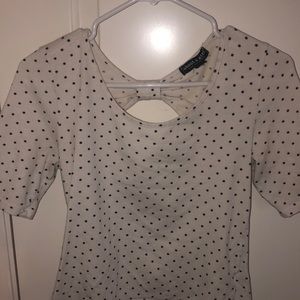 I’m selling a white and black polka dot shirt with a bow design in the back.